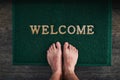 Home is where you can kick off your shoes. High angle shot of a mans bare feet standing on a welcome mat. Royalty Free Stock Photo