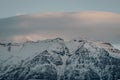 High angle shot of the mountains covered with snow under the cloudy sunset sky Royalty Free Stock Photo