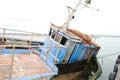 High angle shot of an old unworkable worn-out rusty fishing boat in the ocean water Royalty Free Stock Photo