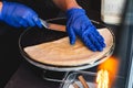 High angle shot of a person with blue gloves making delicious crepe