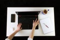 High angle shot of a person working at a work desk with a laptop, a cup of coffee, and mobile phone Royalty Free Stock Photo