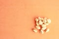 High angle shot of a pile of pistachios isolated on an orange surface