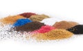 High angle shot of piles of different colorful spices on a white surface