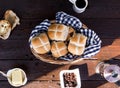 High angle shot of raisin buns on the table with butter and a cup of coffee under the sunlight