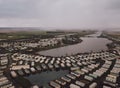 High angle shot of the rectangle houses on the fields by a beautiful foggy pond