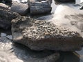 High angle shot of rocks with erosion holes on a sandy beach in  Kyauk Phyu, Rakhine, Myanmar Royalty Free Stock Photo