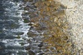 High angle shot of a rocky shoreline with waves crashing against the rocks Royalty Free Stock Photo