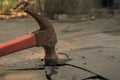 High angle shot of a rusted hammer destroying a rocky surface