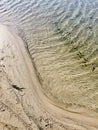 High angle shot of a sandy beach and sea waves with interesting textures Royalty Free Stock Photo