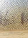 High angle shot of a sandy beach and sea waves with interesting textures Royalty Free Stock Photo