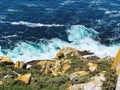 High-angle shot of sea waves slamming on rocks on a beach