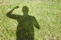 High angle shot of the shadow of a person stretched on a grass-covered field Royalty Free Stock Photo