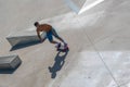 High angle shot of a skateboarder doing tricks on his skateboard during a sunny day Royalty Free Stock Photo