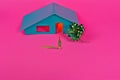 High angle shot of a small house figure with a bow isolated on a pink background Royalty Free Stock Photo