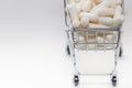 High angle shot of a small shopping cart full of white pills. White background, copy space. Close up shot. Shopping online, buying Royalty Free Stock Photo