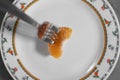 High angle shot of a tangerine and a fork on a plate