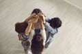 High angle shot of team of little children standing close in circle and joining hands