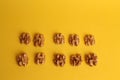 High angle shot of ten pieces of walnut isolated on a yellow surface Royalty Free Stock Photo