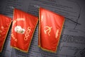 High angle shot of three red historical flags on a document