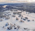 High angle shot of a town covered in the snow surrounded by forests and a lake under a cloudy sky Royalty Free Stock Photo