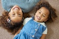 Were sisters who get along well. High angle shot of two adorable little girls lying on the floor together. Royalty Free Stock Photo