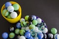 High angle shot of two bowls filled with colorful marbles, on a black surface Royalty Free Stock Photo
