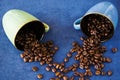 High angle shot of two colorful mugs full of roasted coffee beans on the table Royalty Free Stock Photo