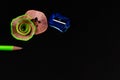 High angle shot of two green pencil shavings and a sharpener on black background Royalty Free Stock Photo