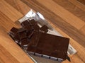 High angle shot of an unwrapped dark chocolate bar on a wooden surface Royalty Free Stock Photo