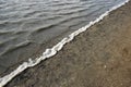 High angle shot of where the wave of the sea meets the sand