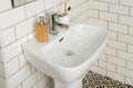 High angle shot of a white bathroom sink with a shiny modern faucet, soap dispenser, toothbrushes Royalty Free Stock Photo