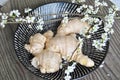 High angle shot of white ginger roots in a basket with cherry blossoms Royalty Free Stock Photo