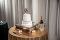 High angle shot of a white wedding cake and a basket with a champagne bottle on the table Royalty Free Stock Photo