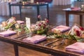 High angle shot of a wooden table with an elegant setting with pink floral decorations Royalty Free Stock Photo