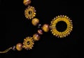 High angle shot of yellow beads of necklace laid in a black surface Royalty Free Stock Photo