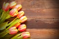 High angle shot of yellow-pink tulip flowers on a wooden surface - empty space for text Royalty Free Stock Photo