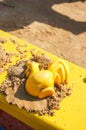 High angle shot of a yellow plastic toy sand form in a cock shape on the border of the sandbox Royalty Free Stock Photo