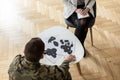 High angle on soldier choosing picture during meeting with psychiatrist