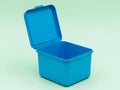 Bright blue plastic lunch box with open lid on a light green background for storage Royalty Free Stock Photo