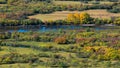 High-angle sunlit colorful wetlands, a river near, autumn trees