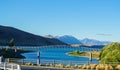 High-angle of Tekapo lake view with footbridge mountains sunlit clear sky background