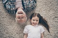 High angle top above photo of two people grandpa little granddaughter lying floor cozy fluffy carpet cheerful positive