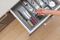 High angle top view cropped photo of woman hand open kitchen drawer by modern door handle, with different cutlery and take spoon Royalty Free Stock Photo