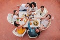 High angle top view of a group of best friends toasting wine glasses smiling and looking up to the camera. Young adult