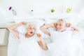 High angle top view photo of two aged grey hair people wake-up o