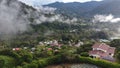 High-angle of town trees around forested mountains clouds on