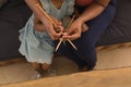 Grandmother teaching her granddaughter how to knitt in living room