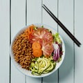 Buddha bowl salad on a pale green table