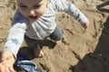 High angle view of a baby boy having his firts steps in the sand