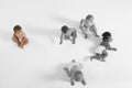 High angle view of baby girl looking at other babies crawling on floor